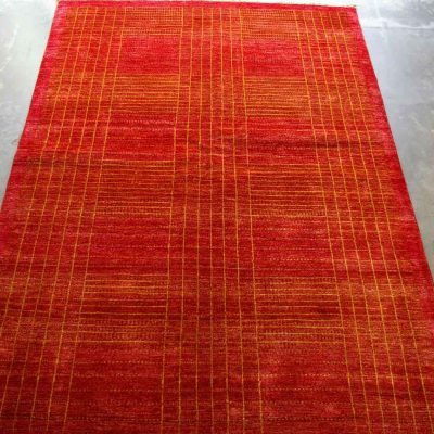 A handmade Gabbeh rug with a bold geometric pattern in shades of red and orange