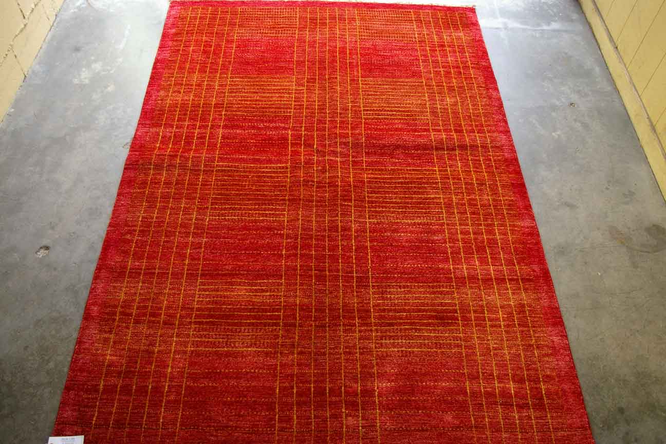 A handmade Gabbeh rug with a bold geometric pattern in shades of red and orange